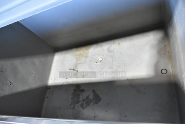 Alt text: Interior view of a commercial ice bin showing light wear and stains, used with a Hoshizaki F-1001MAH ice machine.