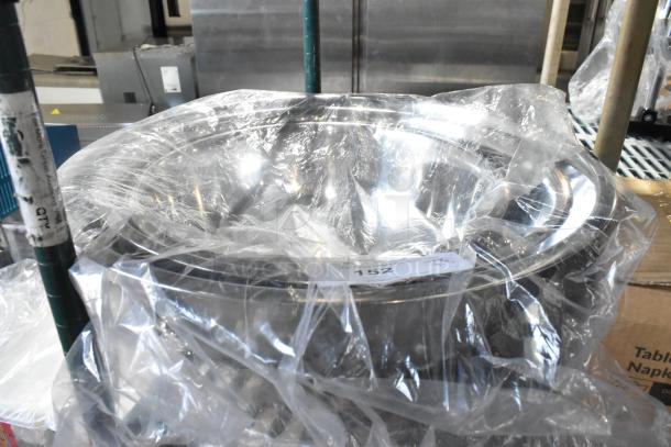 Three new metal bowls wrapped in plastic packaging, slightly scratched. Sale tag shows lot number 152.