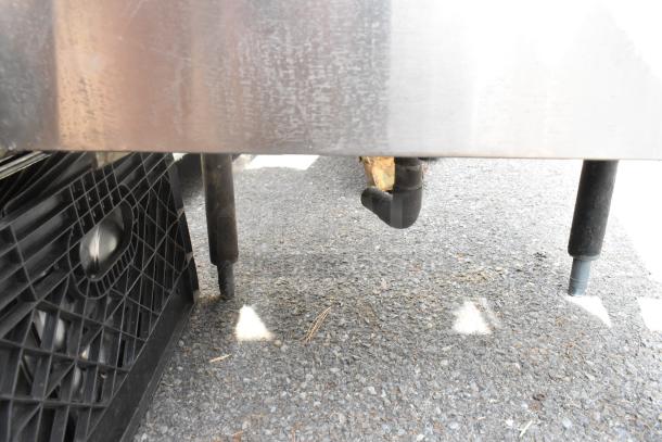 Krowne 18-24 stainless steel ice bin missing two legs, shown outdoors. Durable construction but incomplete.