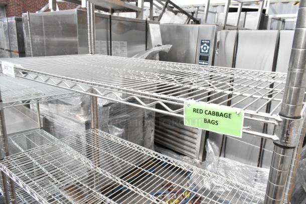 Chrome 4-tier wire shelving unit on commercial casters, good condition. Features "Red Cabbage Bags" label. Buyer dismantles.