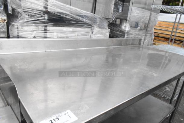 Stainless steel table with under-shelf, polished finish, used condition, visible auction tag with item number.