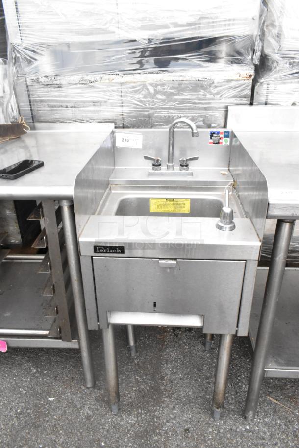 Perlick stainless steel single bay sink with dual taps, in used condition. Features include sturdy legs, brand label, and caution sticker.