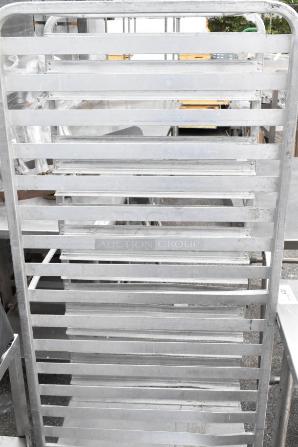 Metal pan transport rack on commercial casters, used condition. Features multiple shelves and durable metal construction.
