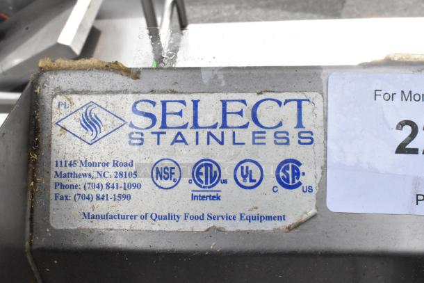 Select Stainless steel single bay wall mount sink with faucet and handles, used condition. Labels certify UL and NSF standards.