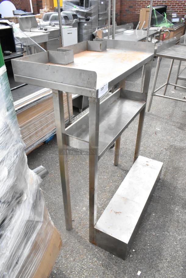 Stainless steel metal table with under shelf, open sides, and raised edges. Some surface rust visible. Auction tag shows "225".