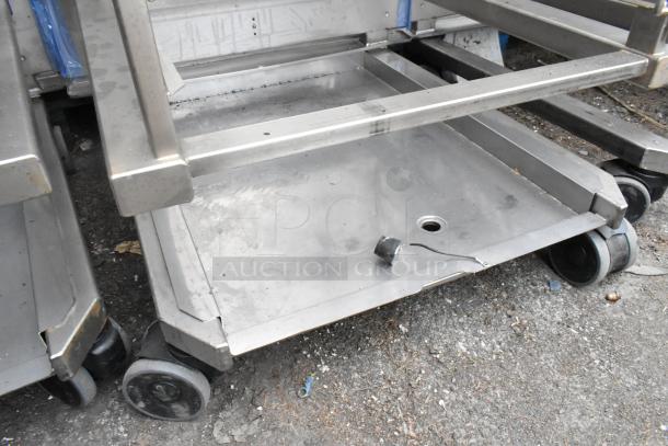 Metal commercial pan transport rack with wire shelves, equipped with commercial casters. Used condition.