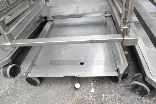 Metal commercial pan transport rack with wire shelves on commercial casters; sturdy condition, suitable for kitchen use.
