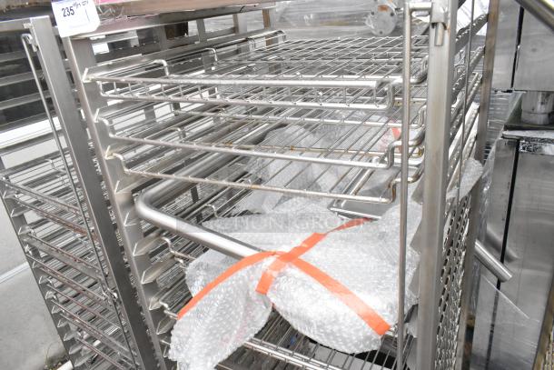 Metal commercial pan transport rack with wire shelves, on commercial casters. Sturdy design, visible in good condition.