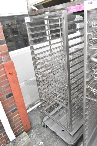 Metal commercial pan transport rack with multiple wire shelves and commercial casters, in good condition.