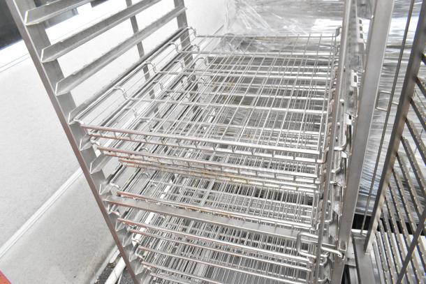 Metal commercial pan transport rack featuring wire shelves and commercial casters, in good condition.