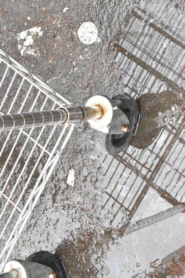 Chrome 4-tier wire shelving unit on commercial casters, outdoor view, reflective surface, slight rust on poles. Buyer dismantles.