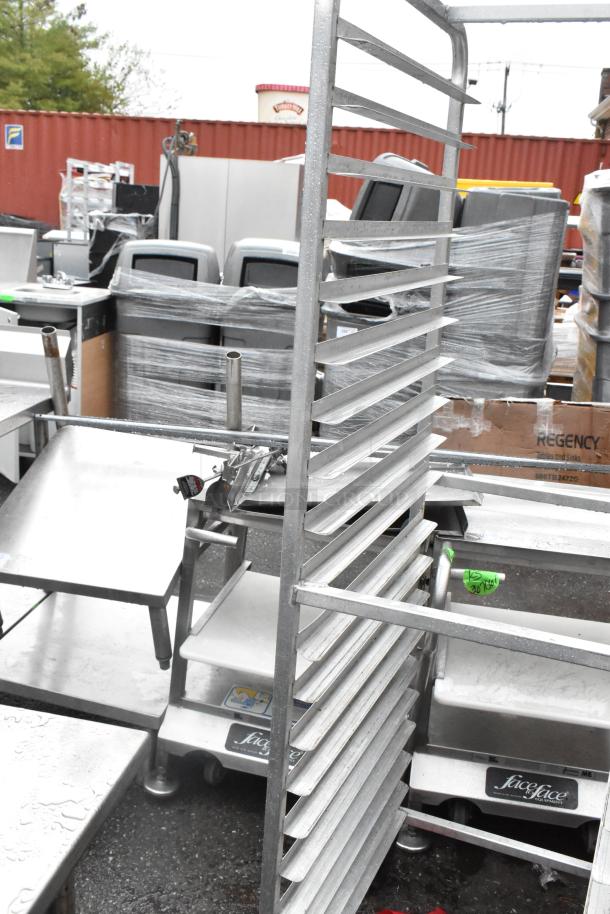 Metal commercial pan transport rack with multiple shelves on sturdy commercial casters, in good used condition.