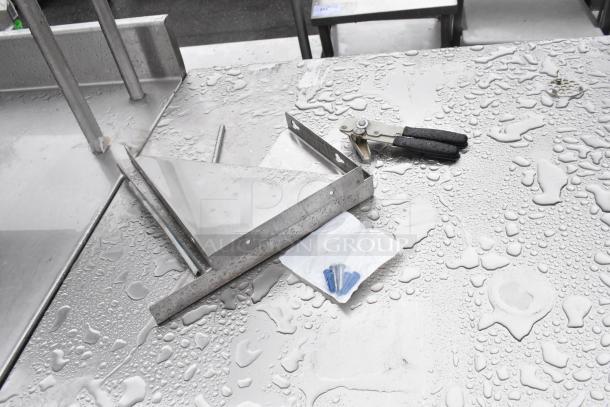 Stainless steel table with water droplets. Includes attachments and screws. Excellent condition, durable surface.
