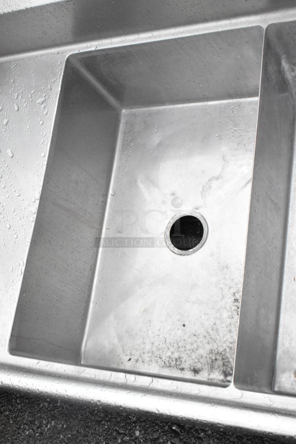 Stainless Steel 3 bay sink with dual drain boards, no legs. Moderately used condition with visible water spots.