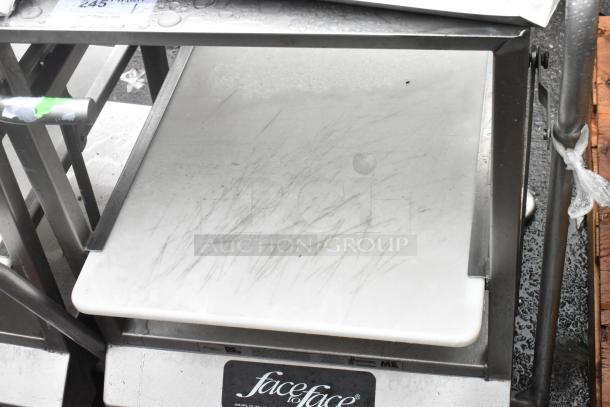 Face to Face stainless steel commercial meat slicer stand with noticeable surface scratches. Brand label visible.