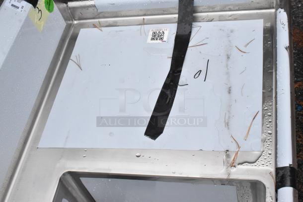 Brand new Regency 600DDTS384RT soiled dish table with 3-compartment sink, right drainboard, 16-gauge, no legs, scratches visible.