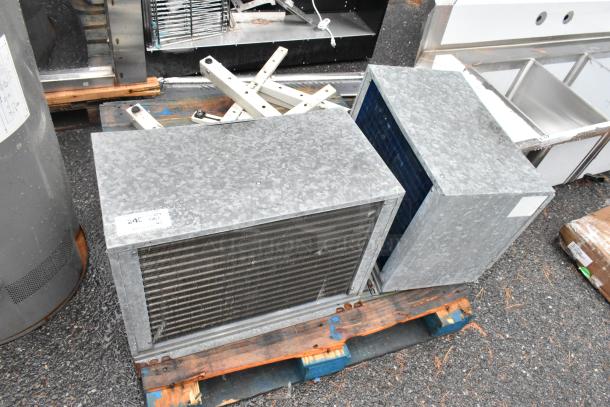 Two metal commercial condensers with visible grilles and metal pieces, placed on a wooden pallet. Auction label indicates "240".
