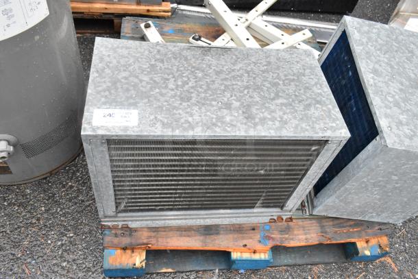 Two metal commercial condensers on a pallet, featuring galvanized finish and visible grilles. Includes additional metal pieces. Condition appears used.