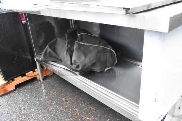 Steelton 30"x60" stainless steel table with enclosed base, sliding doors, and 4" backsplash, contents visible inside.