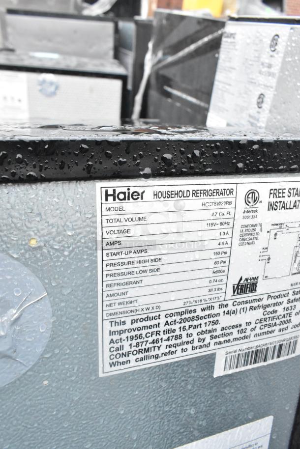 Close-up of Haier mini cooler model HC27SW20RB label showing specifications: 115V, 4.5A, 2.7 cu ft capacity, 38.3 lbs.