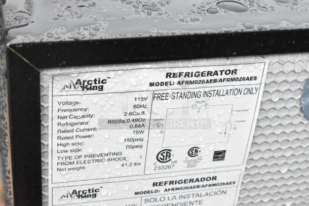 Auction image showing Arctic King refrigerator label, model AFRM026AEB. Features 115V, 2.6 cu. ft. capacity, energy-efficient R600a refrigerant.
