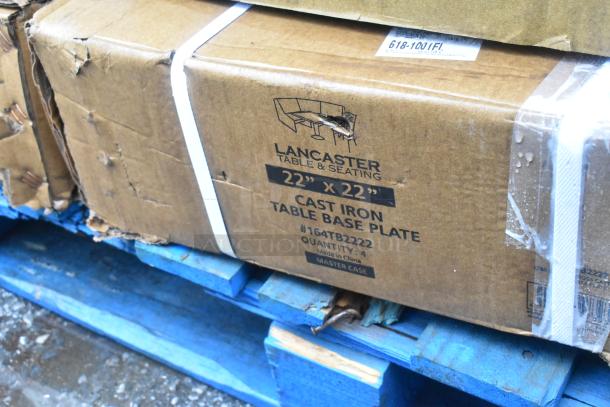 Box labeled "Lancaster 22" x 22" Cast Iron Table Base Plate, #164TB2222," resting on a blue pallet. Boxes appear slightly worn.