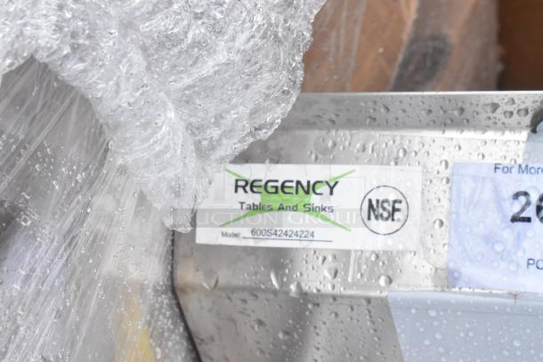 Brand new Regency 600S42424224 stainless steel 4 bay sink, scratch and dent condition, with dual drain boards, no legs.