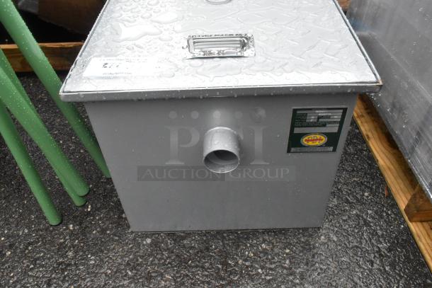 "Brand new Regency 600GT15 30 lb. grease trap, scratch and dent, 15 GPM, 2-inch non-threaded connections, visible labels."