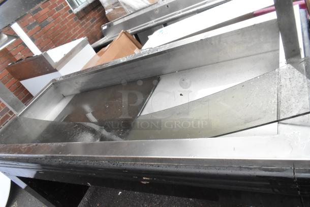 Metal commercial heated buffet station with stainless steel construction. Visible wear and signs of use. Ideal for food service.