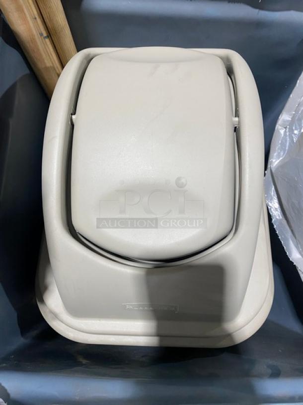 Rubbermaid Untouchable Series gray swing top lid, model FG266400GRAY, shown on a gray trash bin. Appears new.