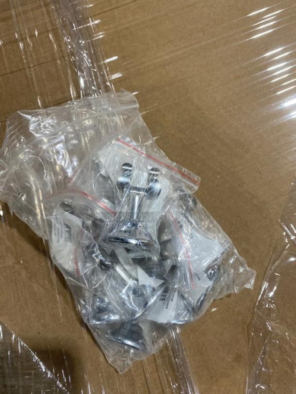Bag of Adcraft stainless steel items on a cardboard surface, unopened in plastic wrap, indicating new condition.
