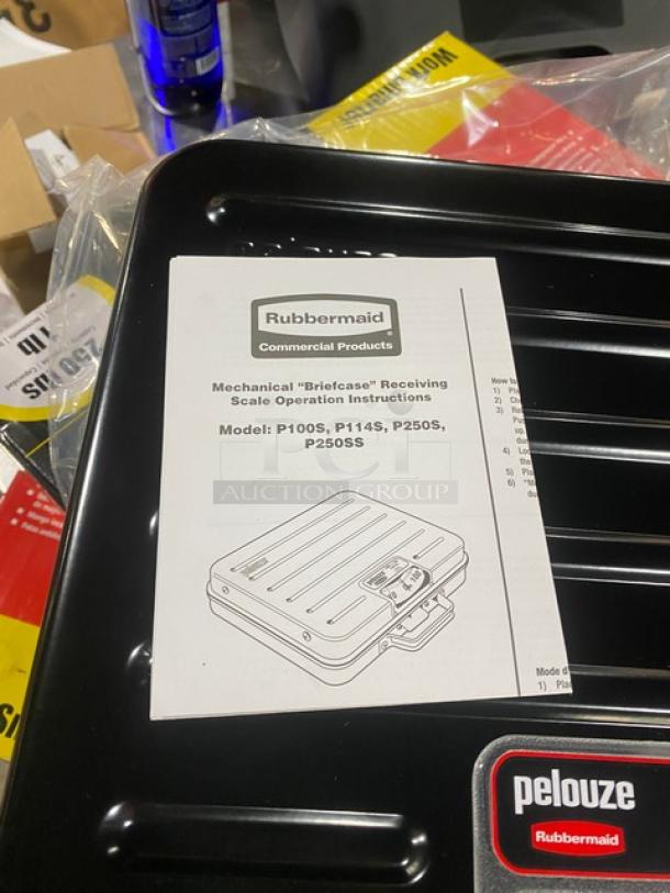 Brand new Rubbermaid Pelouze Series black briefcase-style mechanical scale, model FGP250S. Capacity: 250 lbs. Includes manual.