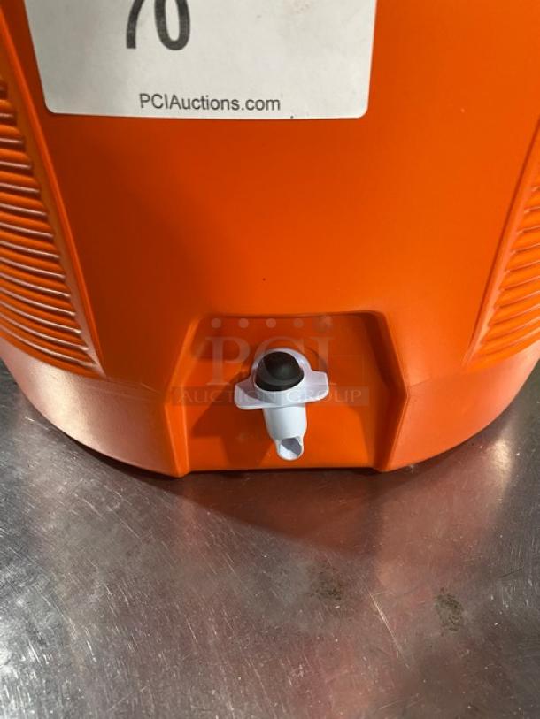 Orange Rubbermaid 10 Gal. insulated water jug with thumb-trigger spigot. Model 1610, new condition, white screw-on lid.