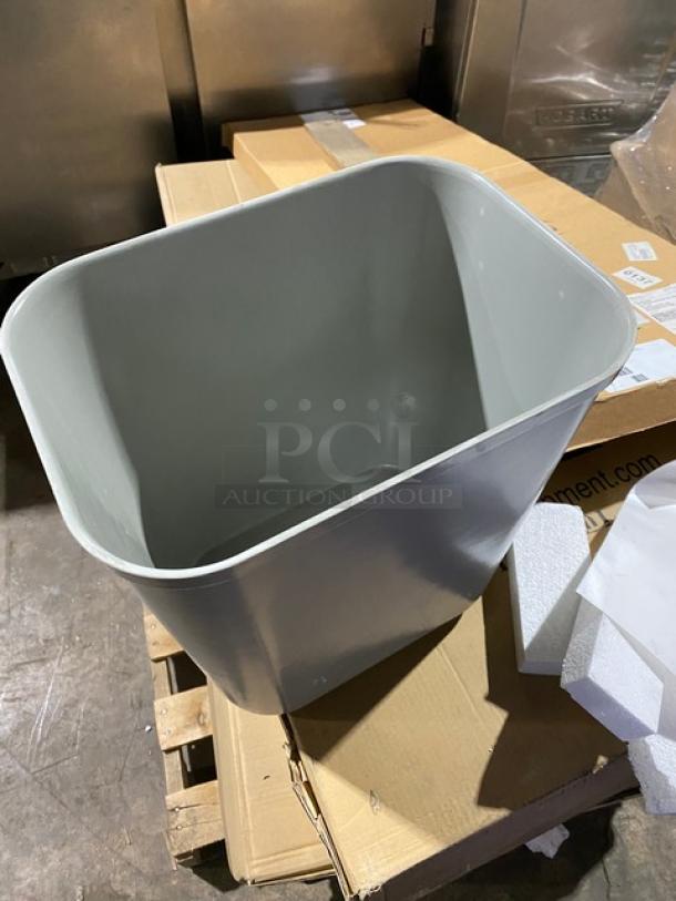 Brand new Rubbermaid Commercial Gray 28 Qt. Rectangular Fire-Resistant Wastebasket, Model 2543, shown on a pallet.