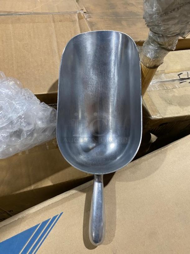 Aluminum scoop on cardboard box, part of a mixed pallet auction. New condition, reflective surface.