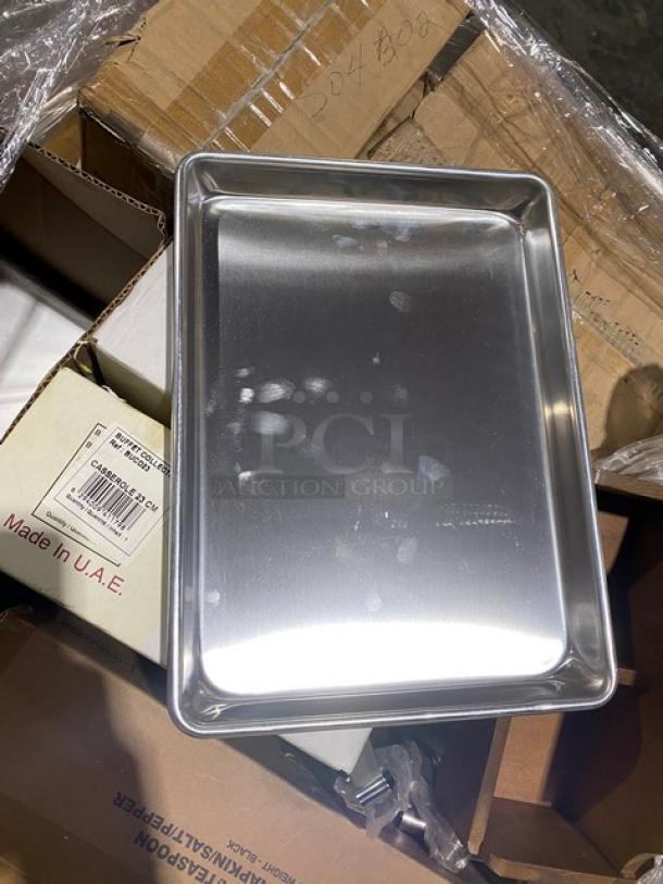 Brand new commercial stainless steel tray on a mixed auction pallet. Includes visible packaging with "Made in U.A.E." marking.