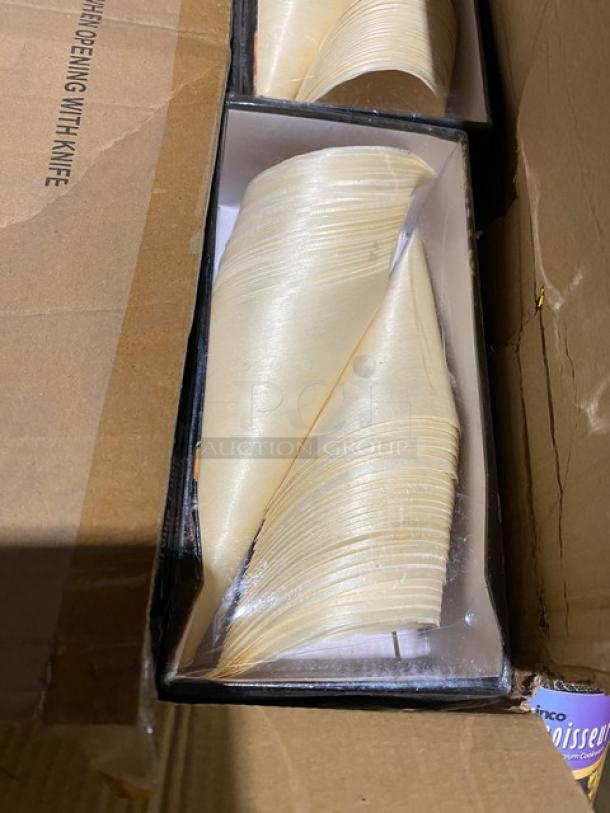 Box with neatly stacked disposable cone-shaped paper food holders inside.