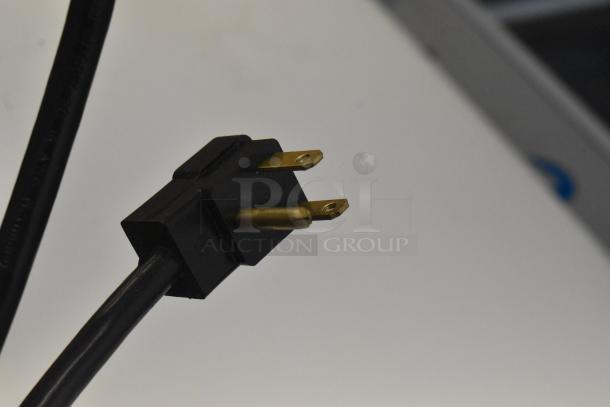 Close-up of a power plug for the Beverage Air SPE48HC-12C refrigerated sandwich prep table, showing gold prongs.