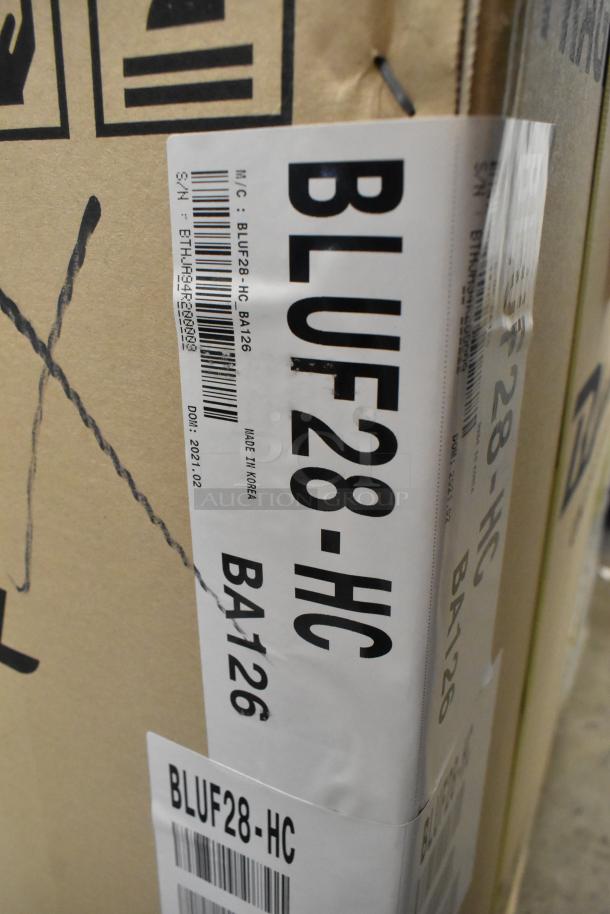 Brand new Blue Air BLUF28-HC stainless steel commercial undercounter freezer in box. 115V, single phase. Model and serial labels visible.