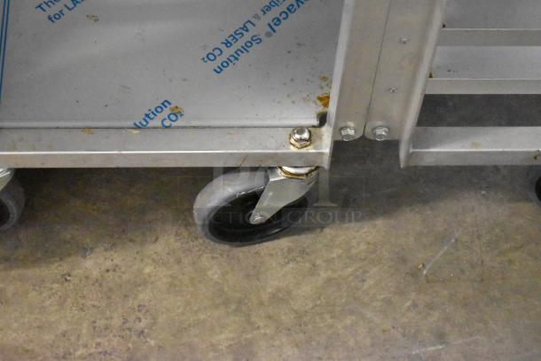 Dutchess DoughXpress DMS-18 NH dough press on metal pan rack with sturdy commercial casters, in used condition.
