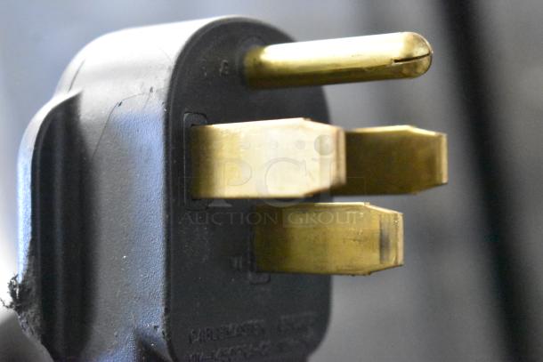 Three-prong industrial power plug for Bunn ICB TWIN SH coffee machine, showing brass pins and black casing.