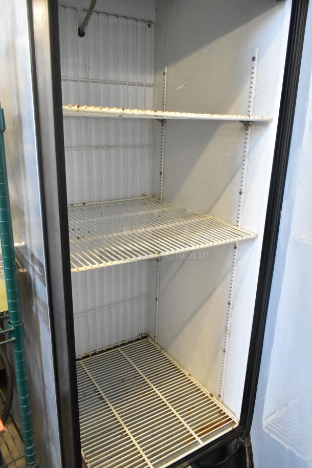 True T-23F stainless steel commercial freezer, single door, interior view, three wire shelves, on commercial casters.
