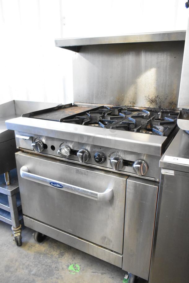 Cook Rite stainless steel commercial gas 4-burner range with griddle, oven, over shelf, and backsplash on casters, used.