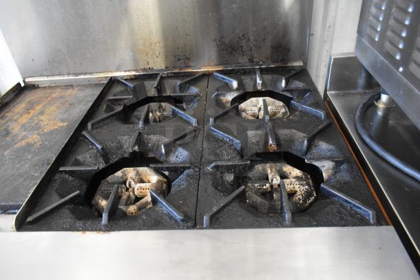 Cook Rite stainless steel commercial 4-burner gas range with flat top griddle, oven, over shelf, and backsplash on casters. Used condition.