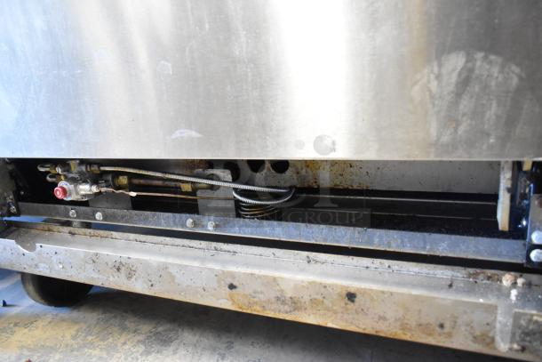 Cook Rite stainless steel gas 4-burner range, flat top griddle, oven, overshelf, backsplash, on casters; visible wear.