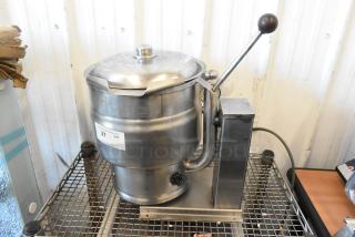 Groen stainless steel electric tilting steam kettle, commercial-grade, countertop design. Visible controls and lever, good condition.