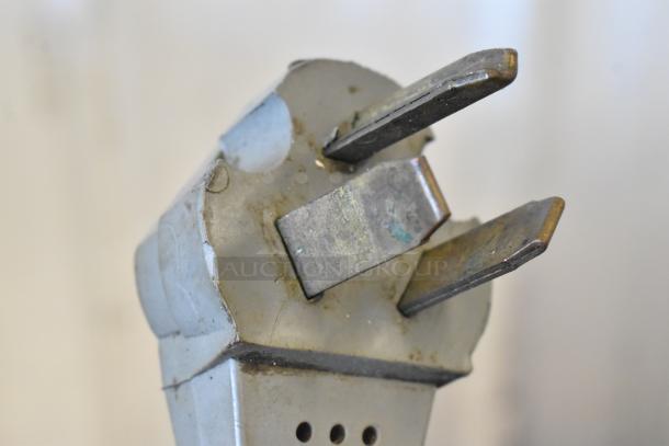 Close-up of metal component, possibly part of kitchen equipment. Slight tarnish visible on surface.