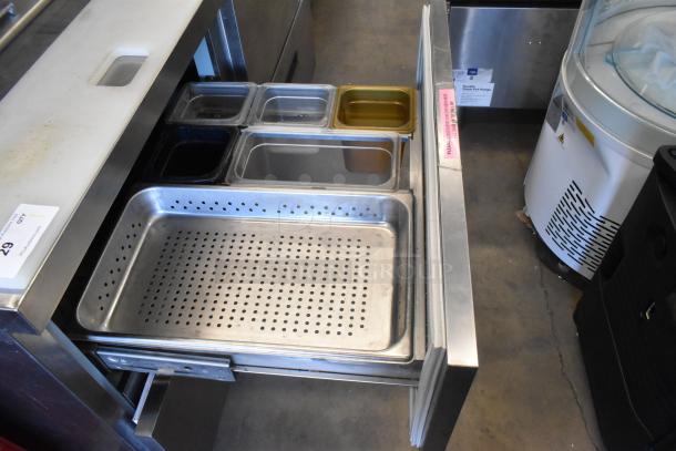 Delfield stainless steel prep table. Includes bain marie, four drawers, overshelf. Good condition, visible storage pans.