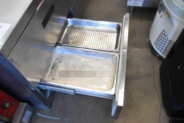 Delfield stainless steel sandwich salad prep table with open drawer showing Bain Marie pans. Equipped with four drawers and overhead shelf.