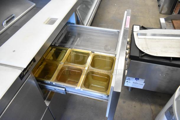 Delfield stainless steel prep table with 4 drawers, bain marie top, and over shelf. Visible logo and stainless finish.